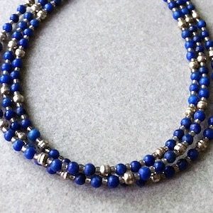 Three strands of blue Lapis Rounds and Diamond Cut Sterling Silver Rounds are a self stacking bracelet with a Dangle at Sterling Clasp