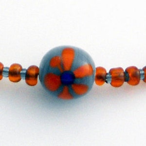 Necklace with two Gray Round Indonesian Rounds with handprinted Orange Flowers are handcrafted in Java, Indonesia with Orange Seed Beads