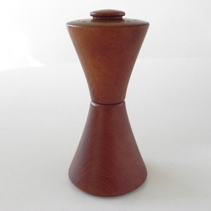 Może przedstawiać: Drewniany zestaw solniczki i pieprzniczki w kształcie klepsydry. Solniczki są wykonane z ciemnobrązowego drewna i mają gładkie wykończenie.