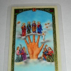May include: A religious image depicting a large hand with a red mark on the palm, surrounded by clouds and figures of people. The hand is reaching up towards a blue sky with white clouds. The figures are dressed in colorful robes and are standing on clouds.