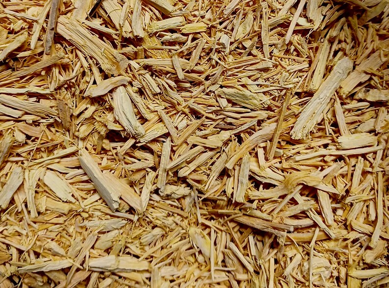 Pu&ograve; includere: Primo piano di un mucchio di trucioli di legno marrone chiaro. I trucioli variano per dimensioni e forma, alcuni lunghi e sottili, altri pi&ugrave; grossi. La consistenza &egrave; ruvida e naturale, suggerendo un prodotto per giardinaggio o paesaggistica.