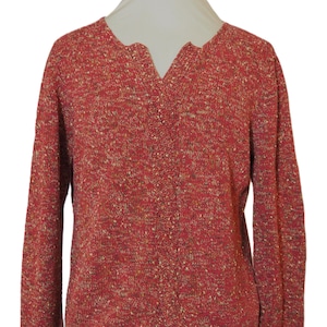 Puede incluir: Un cárdigan de punto rojo y crema moteado con cuello en V y mangas largas.