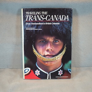 May include: A book cover with a photo of a man in a red uniform with a gold trim hat. The book title is "Traveling the Trans-Canada From Newfoundland to British Columbia" by William Nowarth, photographed by George F. Mobley. The book is published by the National Geographic Society.