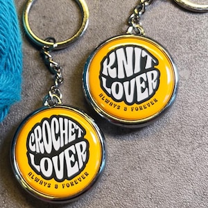 May include: Two yellow metal keychains with silver rings. One keychain says "Knit Lover Always & Forever" and the other says "Crochet Lover Always & Forever".