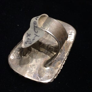 Pu&ograve; includere: Anello d'argento con una pietra di forma quadrata incastonata in una montatura a castone. L'anello &egrave; timbrato con il testo "STERLING" sul retro.