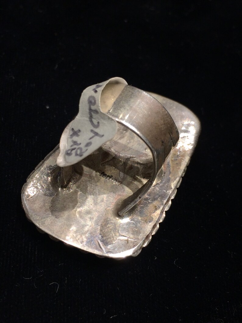 Pu&ograve; includere: Anello d'argento con una pietra di forma quadrata incastonata in una montatura a castone. L'anello &egrave; timbrato con il testo "STERLING" sul retro.