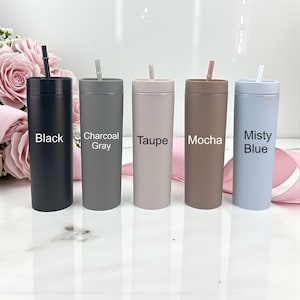 Puede incluir: Cinco vasos aislados en negro, gris carb&oacute;n, topo, moca y azul brumoso, cada uno con una pajita a juego. Los nombres de los colores est&aacute;n impresos en la parte delantera de cada vaso. Los vasos son cil&iacute;ndricos y parecen ser de metal.