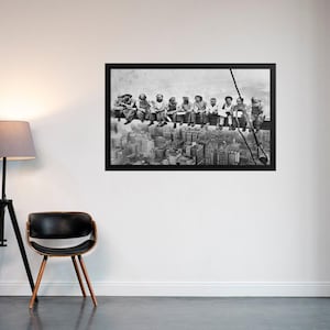 May include: Black and white photograph of a group of construction workers sitting on a beam high above the city. The workers are all wearing hard hats and work clothes. The city skyline is visible in the background.