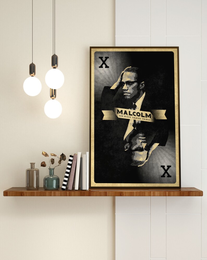 May include: A black and white poster with a portrait of Malcolm X. The poster is in the style of a playing card, with the letter 'X' in the top left and bottom right corners. The text 'MALCOLM OUR BLACK SHINING PRINCE' is printed in gold on a banner.