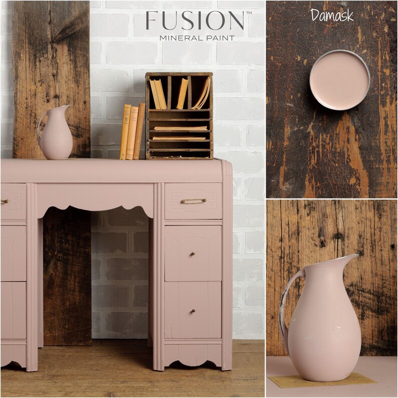 May include: A vintage-style desk painted in a soft pink color called "Damask" by Fusion Mineral Paint. The desk has a curved top and three drawers on each side. The desk is sitting on a wooden floor. The paint color is shown in a small sample pot and on a pitcher.