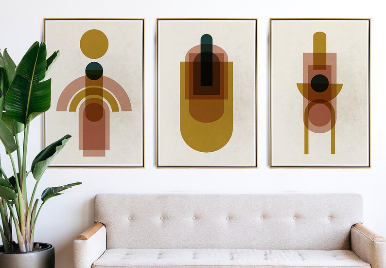 May include: Three abstract geometric art prints with a beige background. The prints feature overlapping shapes in shades of brown, yellow, and teal.