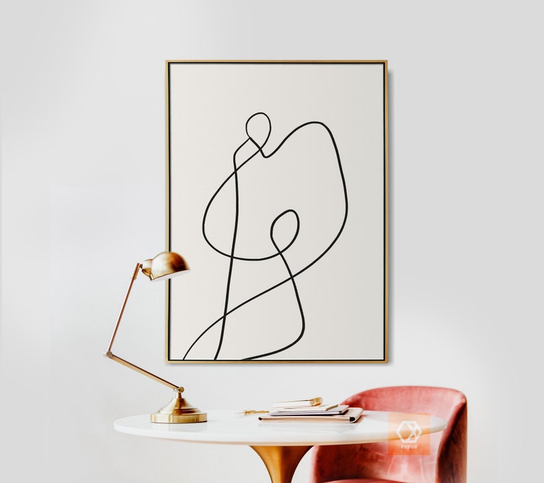 May include: A black and white abstract line art print in a gold frame. The print features a single continuous line that forms a shape resembling a person.