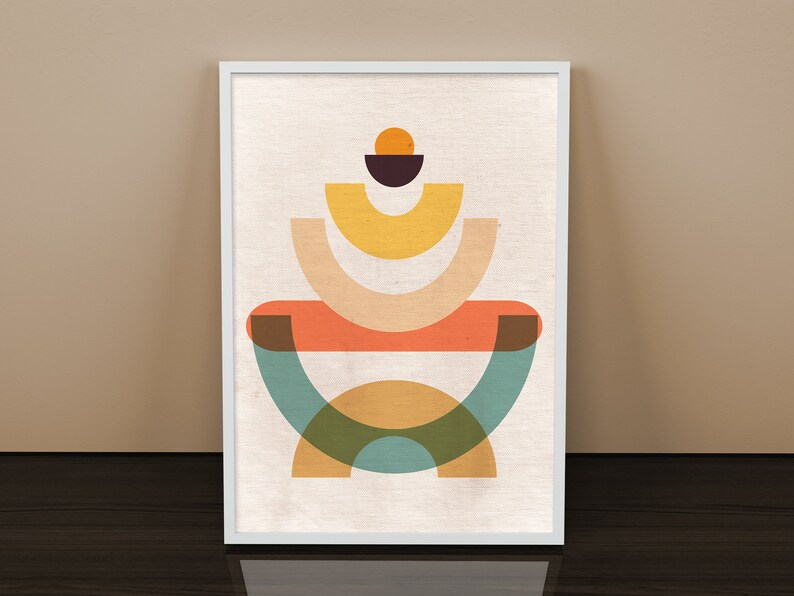 May include: Abstract geometric art print featuring a layered design of overlapping circles and semi-circles in shades of orange, yellow, green, and brown. The print is framed in a white frame.