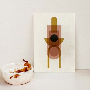 May include: Abstract geometric art print with overlapping shapes in shades of brown, gold, and black. The print features a circle, rectangle, and a tall, thin rectangle.