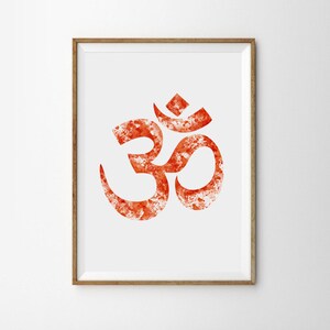 May include: A framed print of the Om symbol in a watercolor style. The symbol is a deep orange color with white accents and a white background.