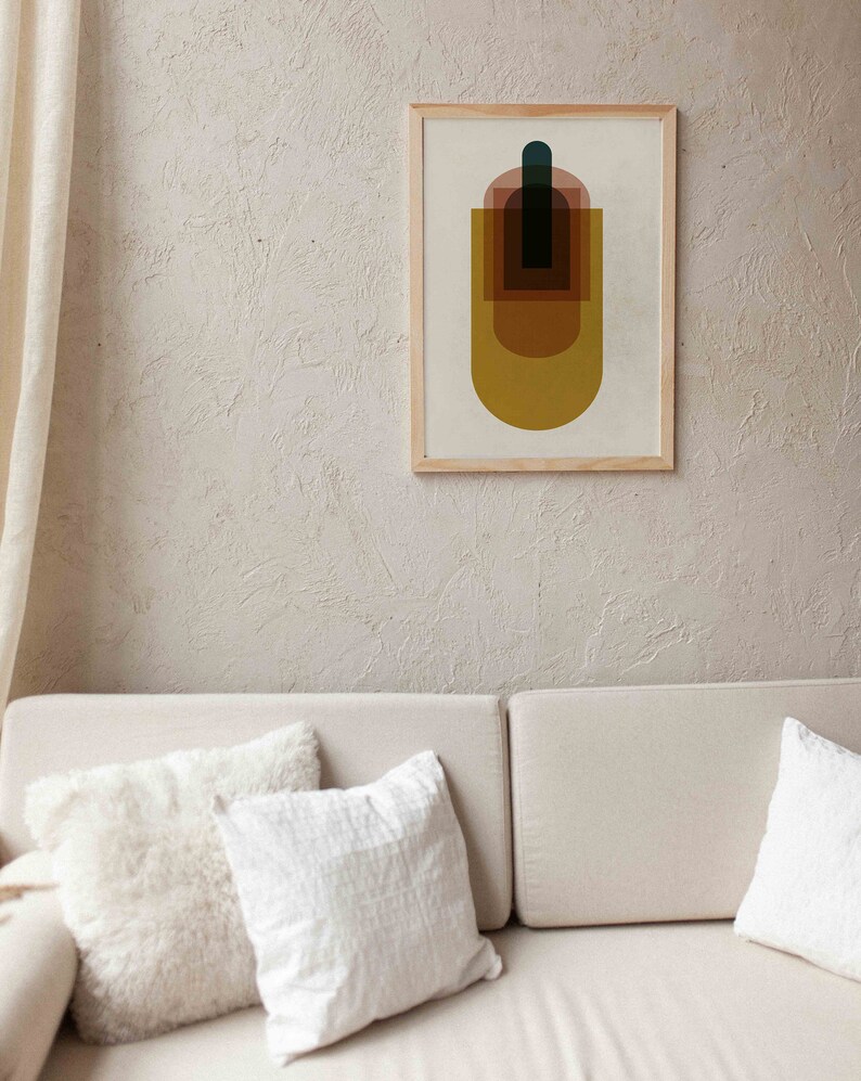 May include: A framed abstract print with a geometric design featuring overlapping shapes in shades of brown, yellow, and blue. The print is on a white background and has a wooden frame.
