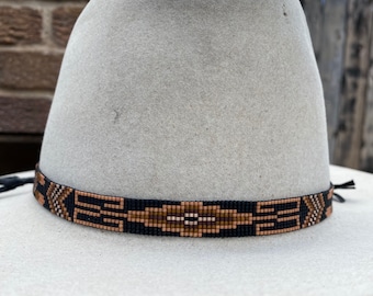 Fascia per cappello con perline nei toni neutri del marrone, beige, crema e nero su sfondo nero. Ideale per cappelli di paglia Panama e da cowboy.