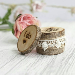 Op de afbeelding: Houten ringendoosje met een kanten rand en de woorden "I do" gegraveerd op de deksel.