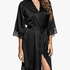 May include: A black satin robe with lace trim around the sleeves and hem. The robe has a tie belt and a front opening.