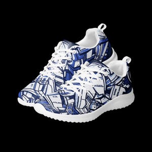 Può includere: Un paio di scarpe sportive con suola bianca e lacci bianchi. Le scarpe presentano un motivo geometrico blu e bianco sulla tomaia. Il design ricorda un paesaggio urbano astratto o graffiti.