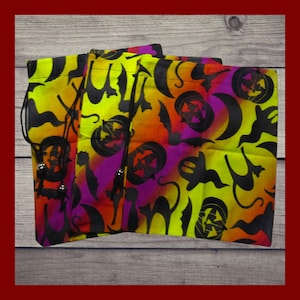 May include: Three Halloween-themed drawstring bags with a vibrant pattern. The bags feature a repeating design of black silhouettes of pumpkins, bats, cats, and moons against a gradient background of yellow, orange, and purple.
