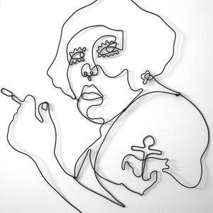 May include: Black wire sculpture depicting a person's face and upper body, holding a cigarette. The artwork is in a minimalist style, with a continuous line forming the facial features, hair, and an anchor tattoo. The sculpture is set against a white background.