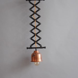 Industrial steel and copper scissor pendant lamp.