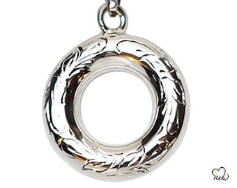 May include: A silver-colored pendant necklace with a circular, open-center design. The pendant features an engraved floral pattern around the outer ring and hangs from a delicate chain. The necklace is displayed against a white background.
