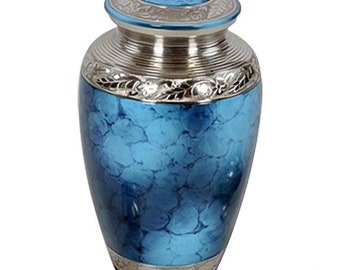 May include: A blue and silver cremation urn with an ornate design. The urn has a silver lid with a floral pattern and a blue body with a marbled effect.
