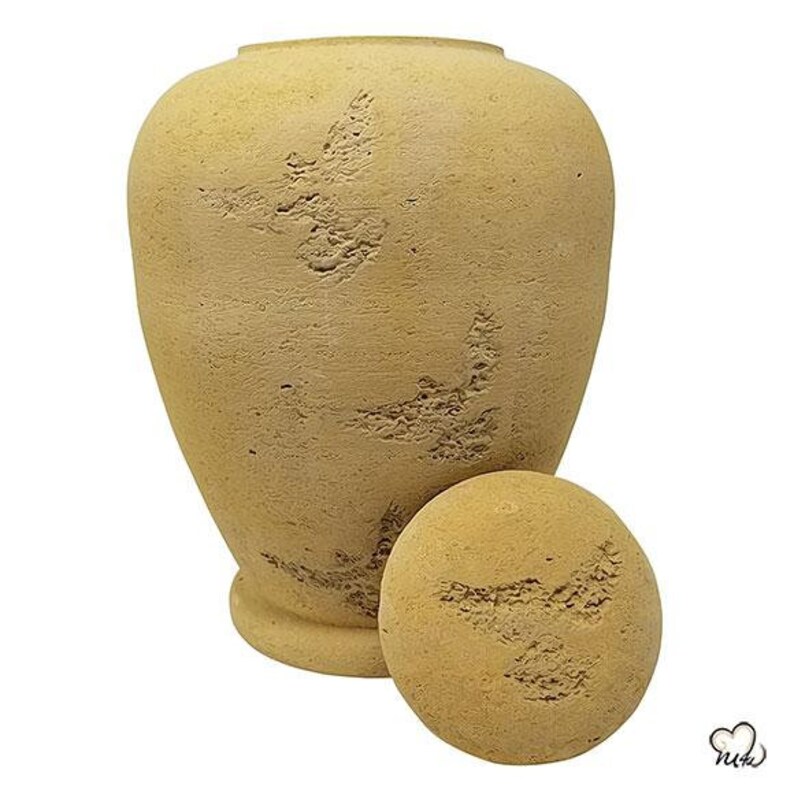 May include: A beige ceramic urn with a lid. The urn has a textured surface and a design of stylised birds.