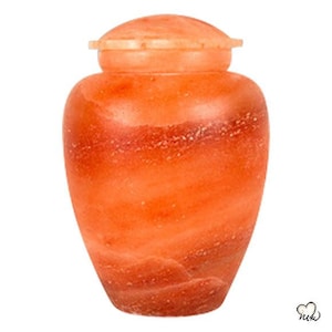 May include: A pink Himalayan salt urn with a lid. The urn is made of natural salt and has a swirling pattern.