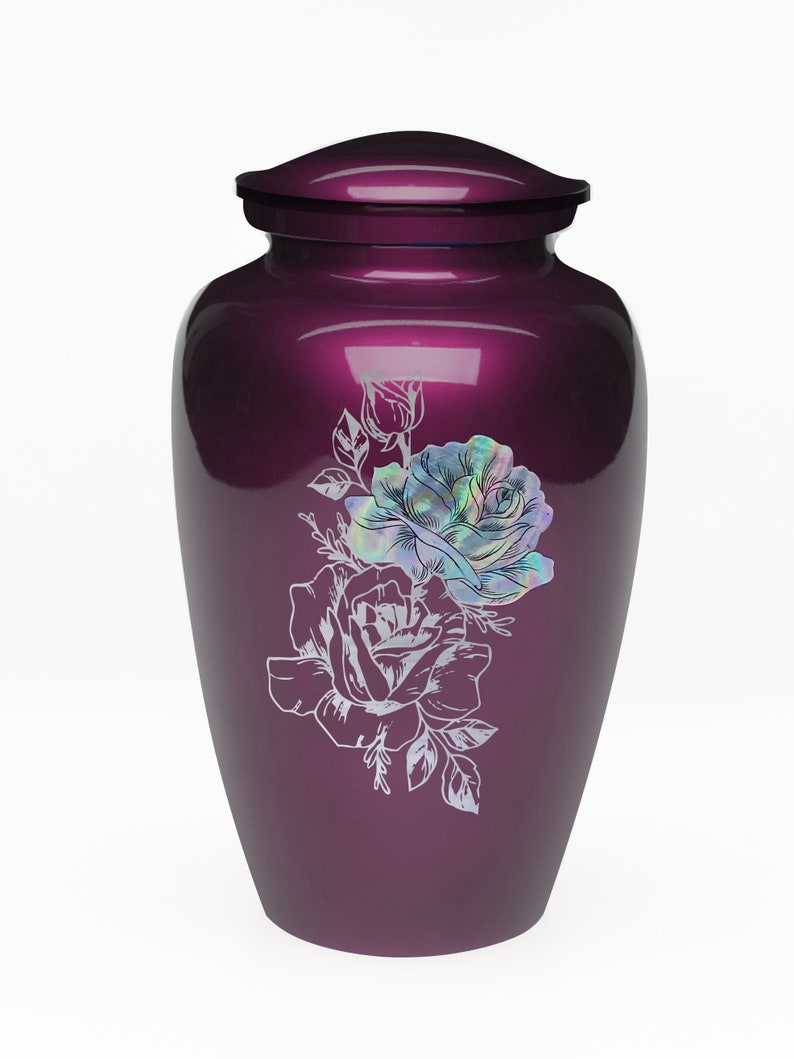 May include: A purple metal urn with a floral design featuring two white roses and leaves. The roses have a pearlescent iridescent finish.