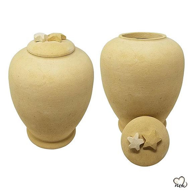 May include: Two beige ceramic urns with star-shaped lids. The urns are round and have a smooth, textured surface.