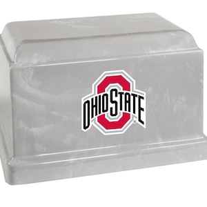 May include: A gray, rectangular urn with a marble-like texture. The Ohio State University logo, featuring a red 'O' with the words 'OHIO STATE' in white, is prominently displayed on the front. The urn has a stepped base and a slightly sloped top.