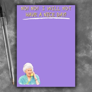 May include: A purple notepad with the text "NO! NO! I WILL NOT HAVE A NICE DAY!" in yellow. An illustration of a woman on the phone is at the bottom. A black and silver pen is on the left.