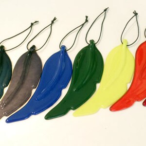 Puede incluir: Siete adornos de alas de &aacute;ngel de vidrio en varios colores, incluyendo azul, verde, rojo, amarillo y negro. Cada ala est&aacute; unida a una cuerda negra para colgar.