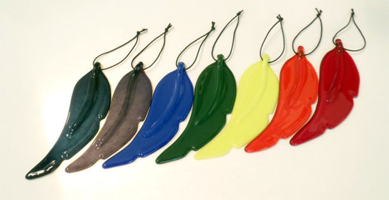 Puede incluir: Siete adornos de alas de &aacute;ngel de vidrio en varios colores, incluyendo azul, verde, rojo, amarillo y negro. Cada ala est&aacute; unida a una cuerda negra para colgar.