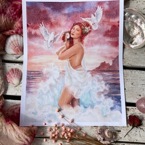 May include: A watercolor painting of a woman with red hair standing in the ocean waves. She is holding a seashell and two white doves are flying around her. The background is a sunset sky with pink and purple clouds.