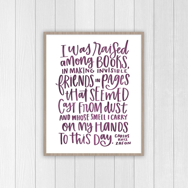 Puede incluir: Texto morado sobre fondo blanco en una impresi&oacute;n enmarcada. El texto dice "Fui criado entre libros, haciendo amigos invisibles en p&aacute;ginas que parec&iacute;an salidas del polvo y cuyo olor llevo en mis manos hasta el d&iacute;a de hoy." El texto est&aacute; firmado "Carlos Ruiz Zafon".