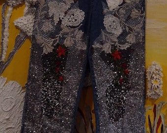 Collectable, decorative jean pants, one-of-a-kind, unique, signed, silver sequence, white laces, red flowers, pearls, wire looking fabric.