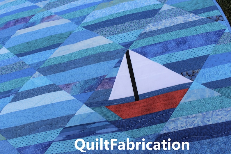 May include: A blue and white quilt with a red and white sailboat in the center. The quilt is made of various shades of blue fabric and has a quilted pattern. The sailboat is a simple design with a white sail and a red hull. The quilt is a great example of a handmade craft.
