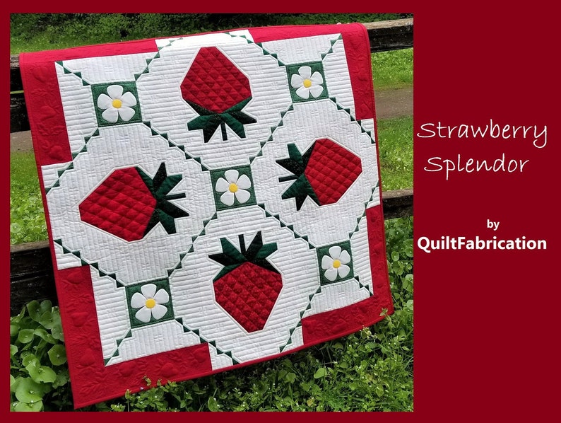 May include: A red, white, and green quilt with a strawberry pattern. The quilt is called "Strawberry Splendor" by QuiltFabrication.