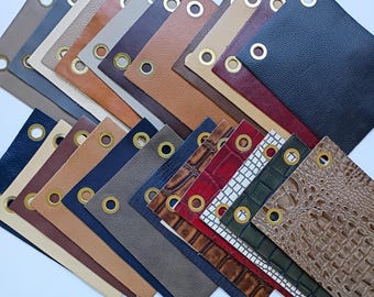 May include: A selection of leather and faux leather samples with eyelets. The samples are arranged in a fan shape and include colours such as brown, black, red, and white.