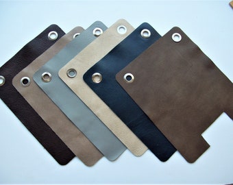 May include: Seven different colors of leather swatches with a silver grommet in the top corner. The swatches are arranged in a fan shape, with the darkest color at the bottom and the lightest color at the top.