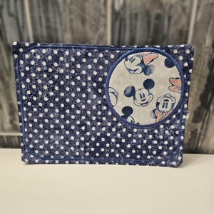 Puede incluir: Tela azul y blanca con lunares con un parche redondo que presenta un fondo blanco con múltiples imágenes de Mickey Mouse y Minnie Mouse.