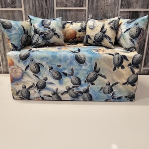 May include: A tissue box cover with a blue and white background featuring a pattern of sea turtles. The cover has four matching pillow covers with the same pattern.