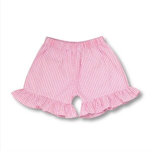 May include: Pink gingham shorts with a ruffled hem.