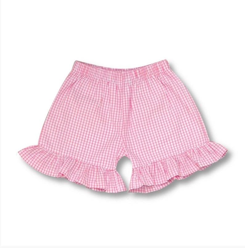 May include: Pink gingham shorts with a ruffled hem.