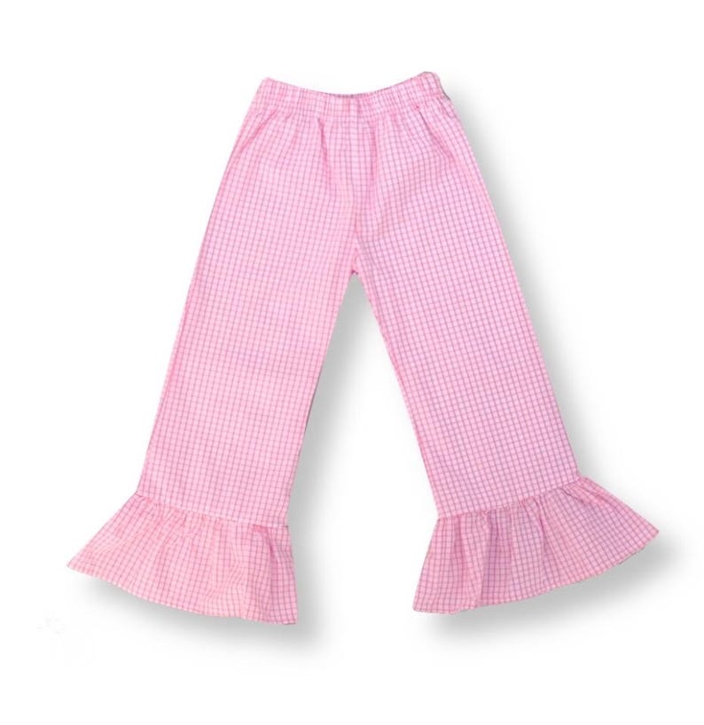 May include: Pink gingham pants with a ruffled hem. The pants have an elastic waistband.