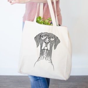 May include: A white canvas tote bag with a black and white illustration of a German Shorthaired Pointer wearing sunglasses. The dog is looking directly at the viewer.